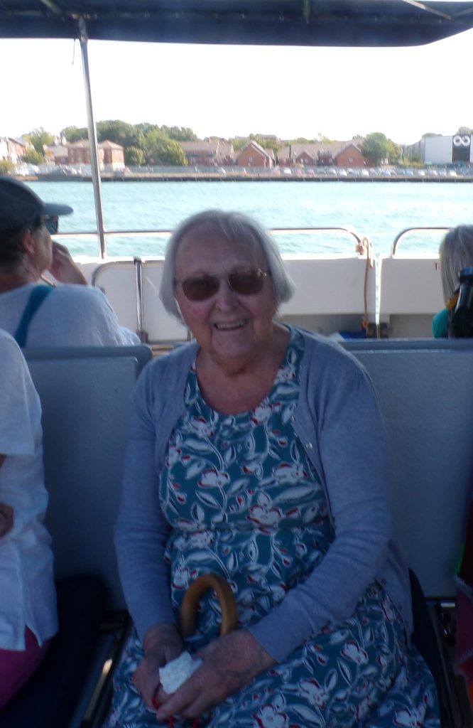 Elderly woman smiling during a boat outing.
