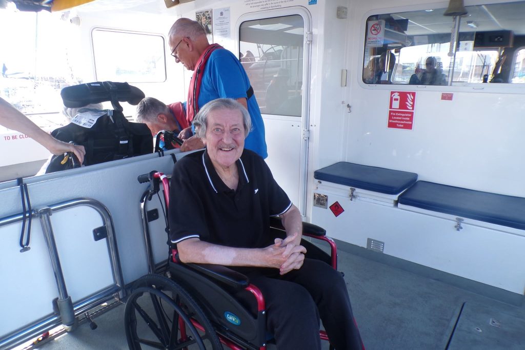 Elderly man enjoying a boat trip in a wheelchair.